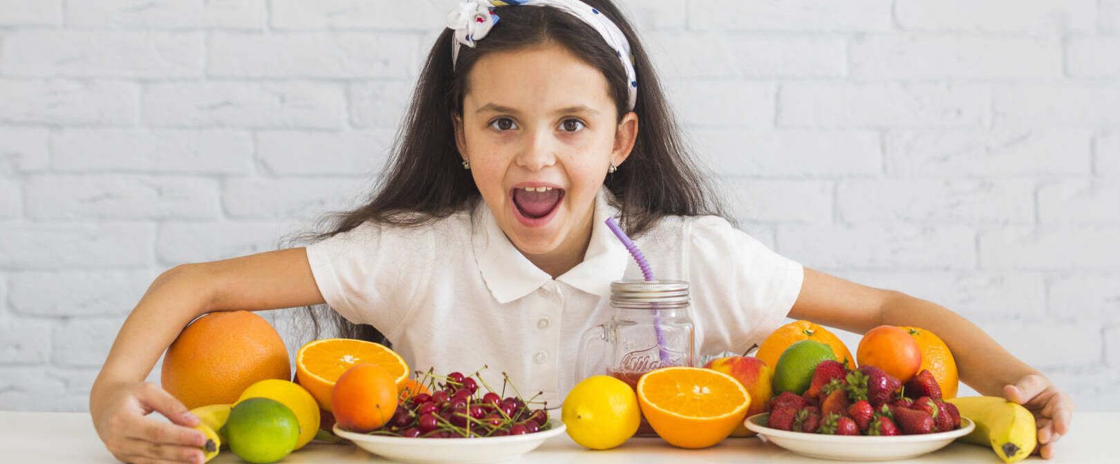 excited-girl-covering-colorful-fresh-organic-fruits